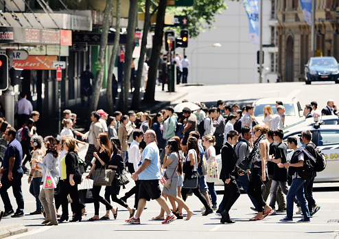People crossing sunlit street